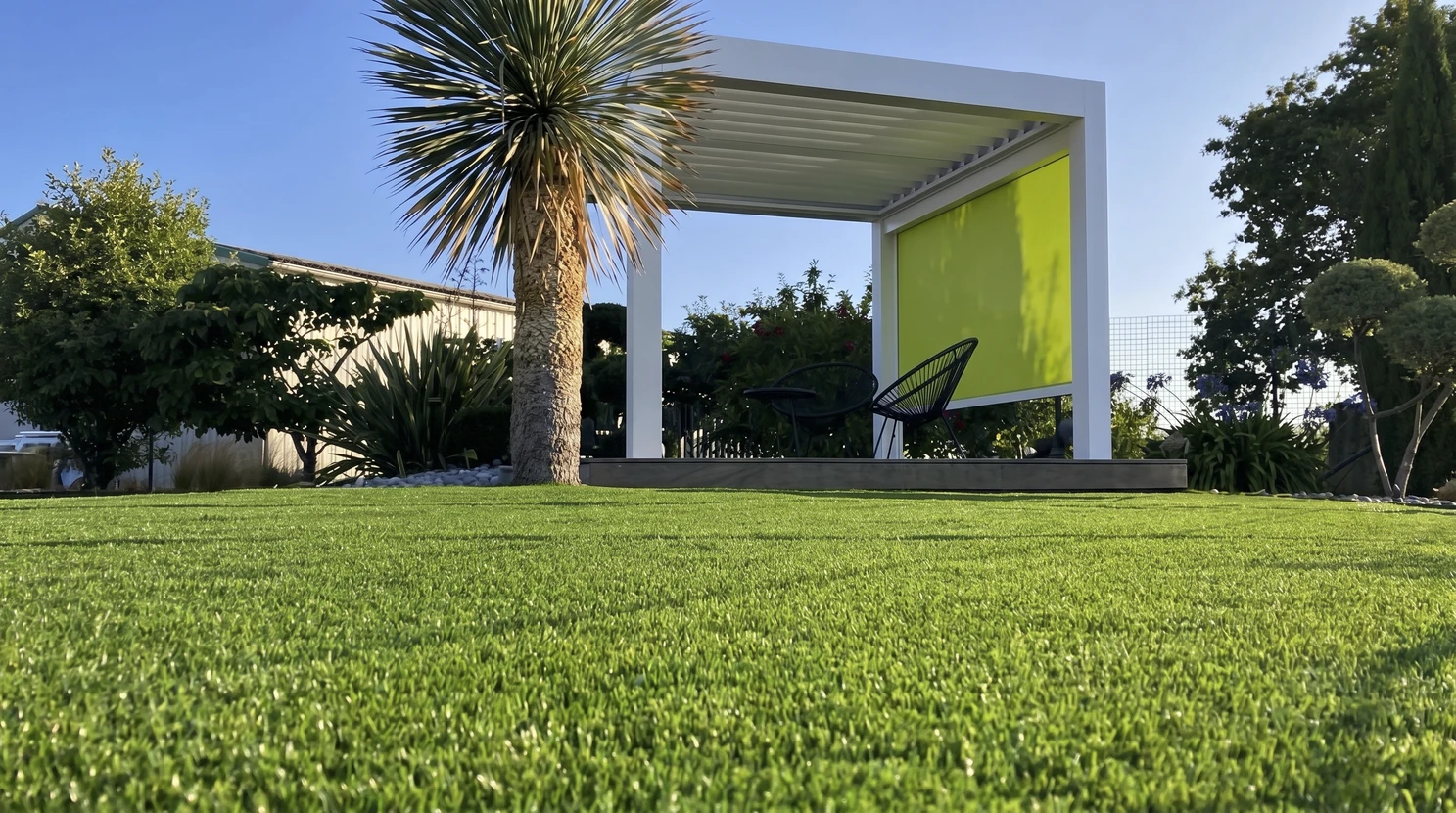 Jardin extérieur moderne avec pelouse en gazon synthétique vert vif au premier plan